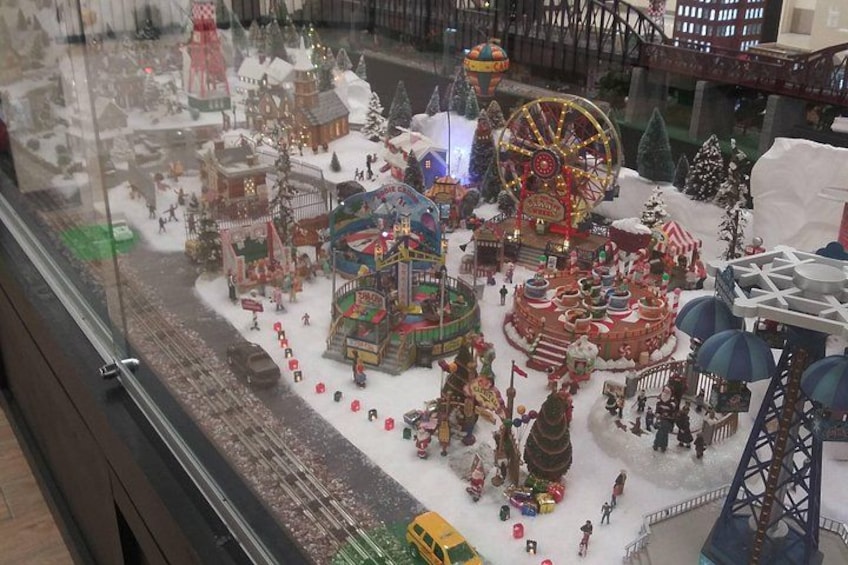 Un modelo detallado de un parque de atracciones con temática invernal, con noria, edificios cubiertos de nieve y diversas atracciones. 2