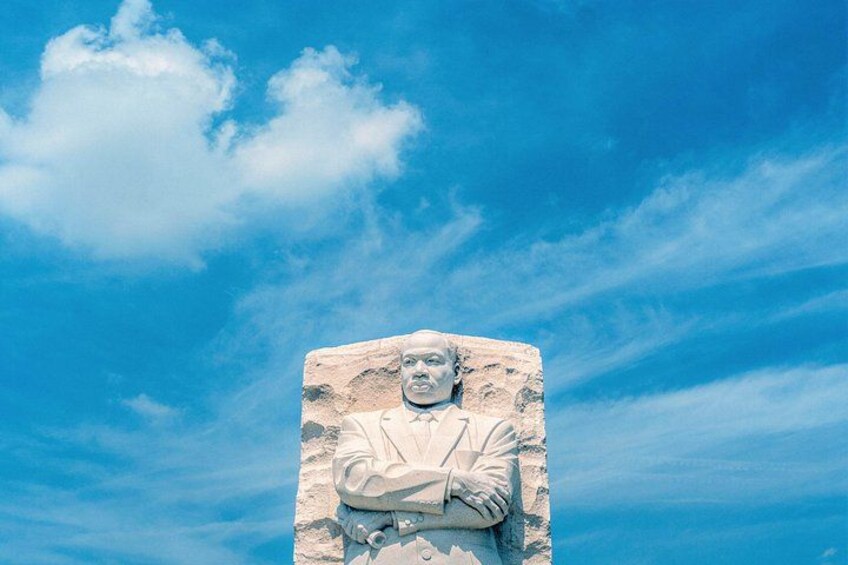 Un monumento de piedra con una figura esculpida, frente a un cielo azul despejado. 2