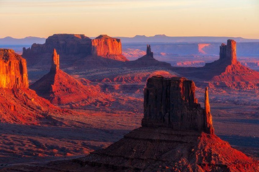 A desert landscape with prominent rock formations during sunset. 2