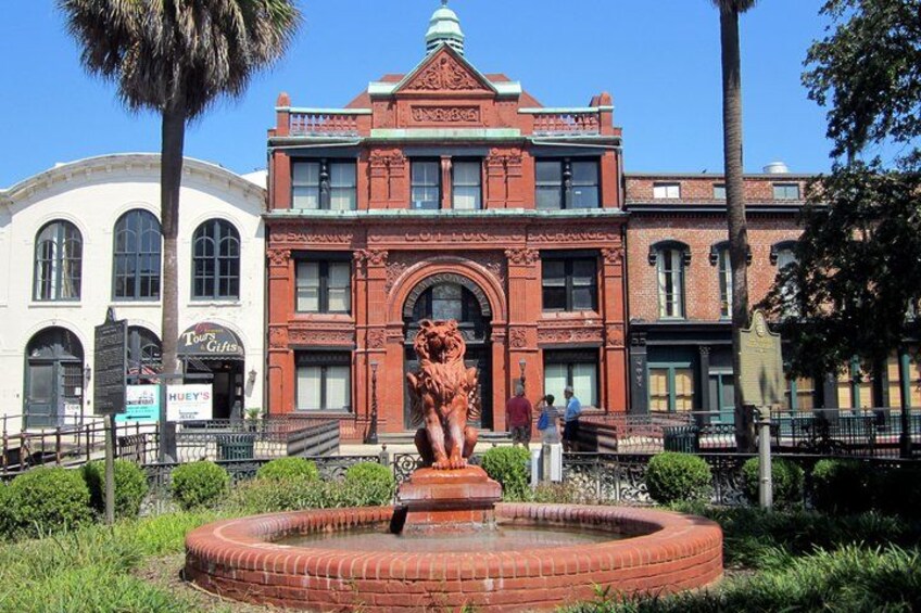 A historic building with a lion statue in front. 2