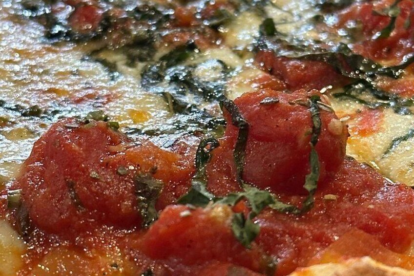 Primer plano de una pizza con salsa de tomate, queso y hierbas. 4