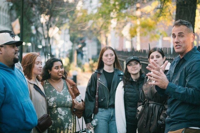 Un groupe de personnes se tient à l’extérieur et est engagé dans une conversation. 3