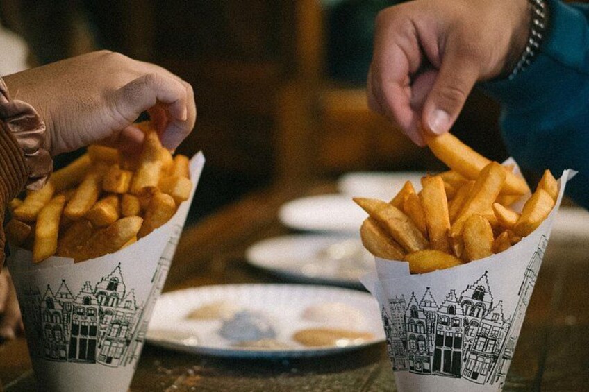 Deux mains tenant des gobelets en papier remplis de frites. 5