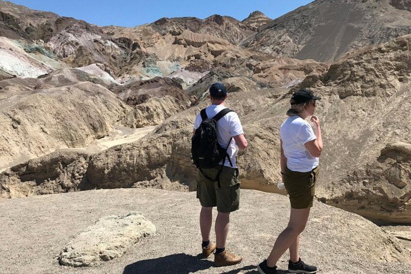 Two hikers on a rocky terrain with a mountainous background. 2