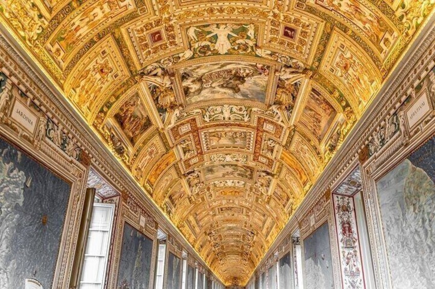 An ornate ceiling with intricate frescoes and gold accents in a grand architectural space. 5