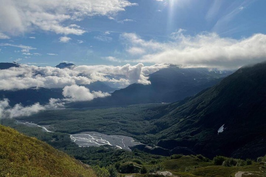 A valley with a river, mountains, and a cloudy sky. 3