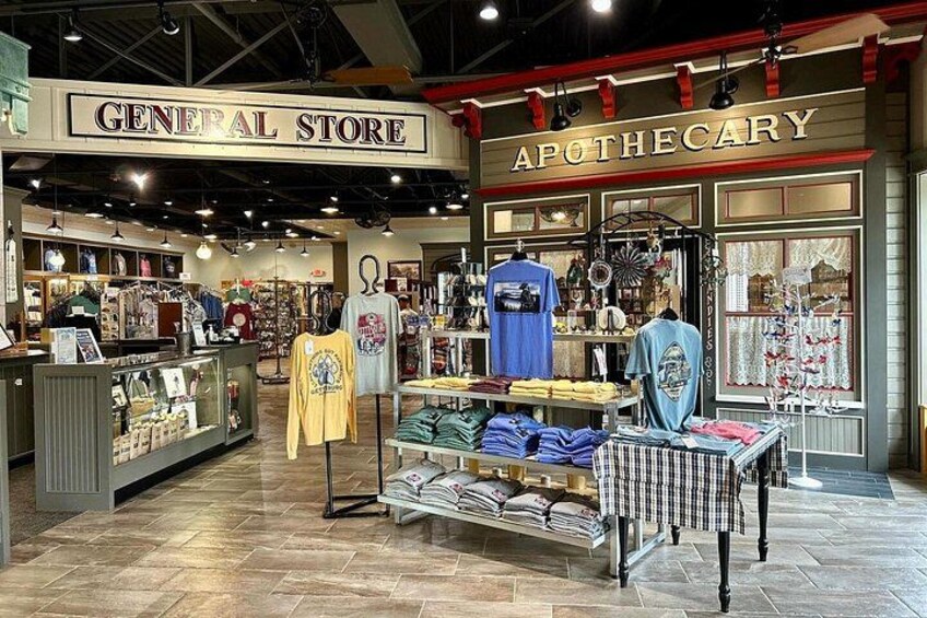 A store interior with clothing racks, a display of folded clothes, and a sign for the General Store and Apothecary. 2