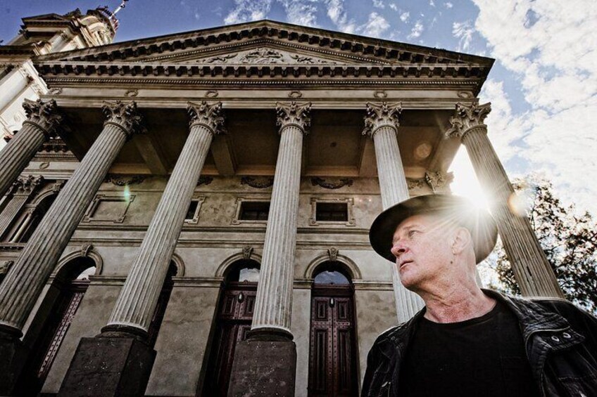 A classical building with columns and a statue. 3