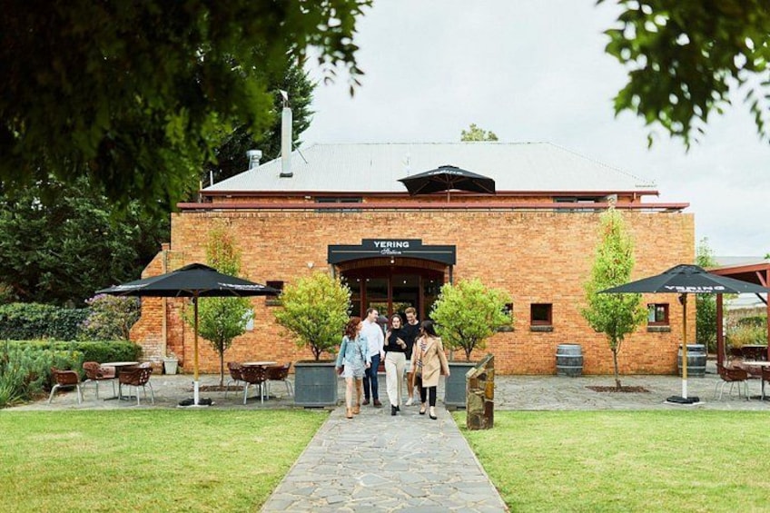A brick building with a sign reading 'YERING' and outdoor seating with umbrellas. 3