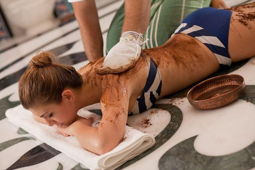 En person ligger på ett massagebord och får behandling av ryggen. 3
