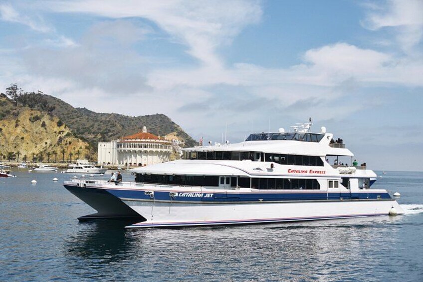 Una embarcación grande blanca y azul llamada 'Catalina Express' en aguas tranquilas, con montañas al fondo. 4