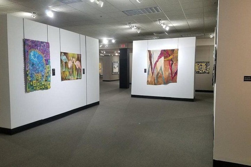 Una galería de arte con varias pinturas grandes exhibidas. 3