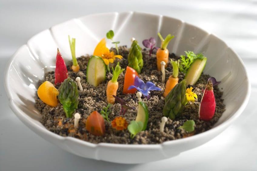 A white bowl with a variety of colorful vegetables and sprouts on a textured surface. 2