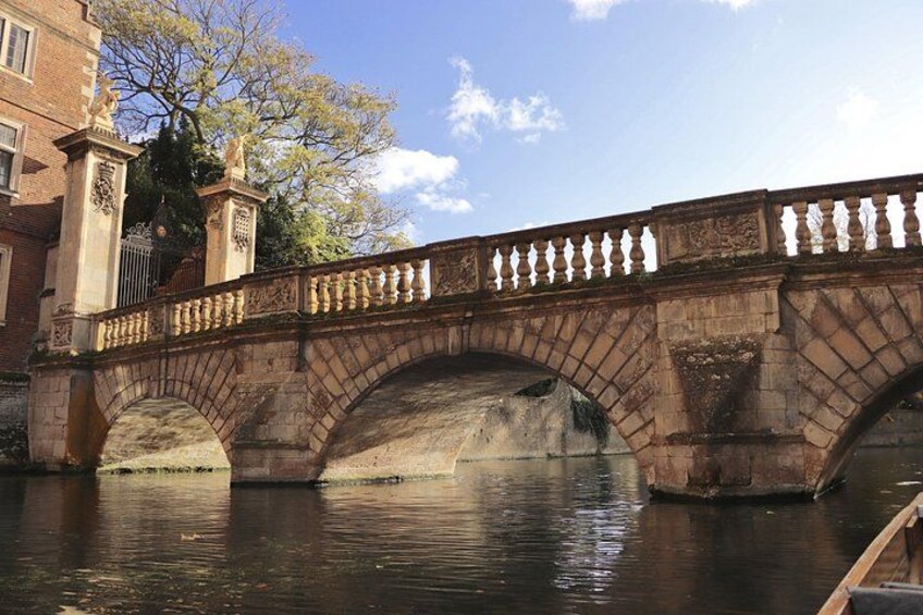 Un puente de piedra con ornamentales barandillas sobre un río tranquilo. 2
