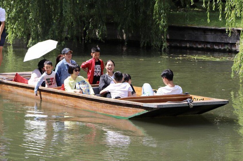 Un grupo de personas en un bote de madera en un río tranquilo. 4