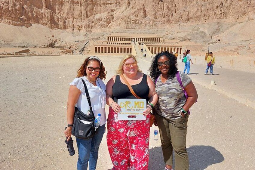 Three people standing in front of a large ancient structure with hieroglyphics. 2