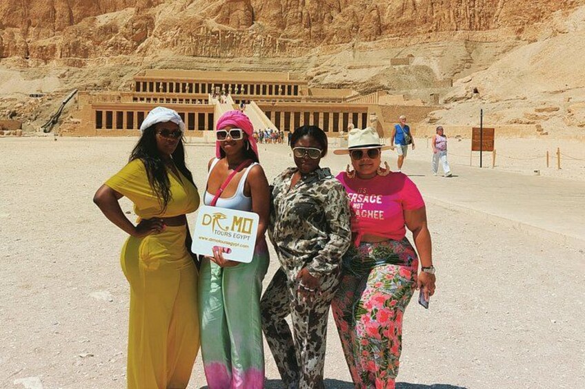 A group of people in front of a large ancient Egyptian structure with hieroglyphics. 3