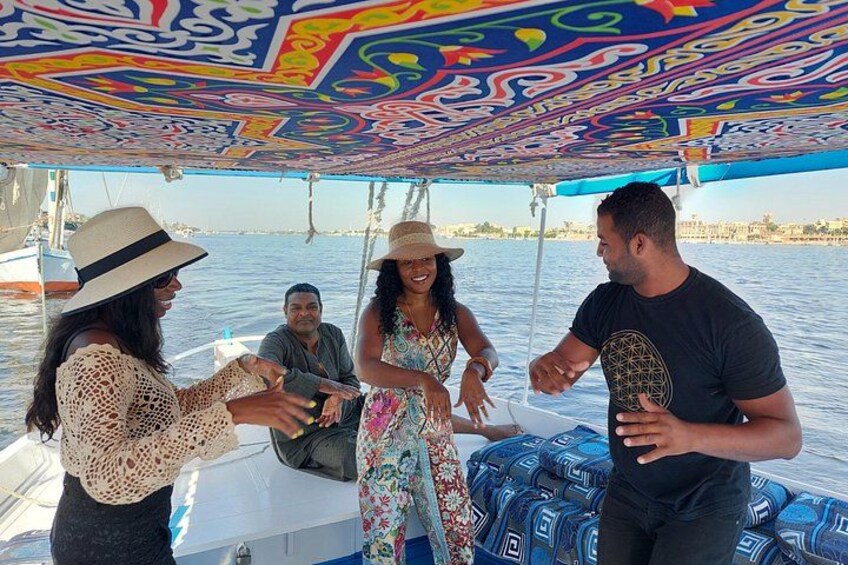 A boat with colorful patterns on the ceiling, a person holding a microphone, and another person gesturing. 4