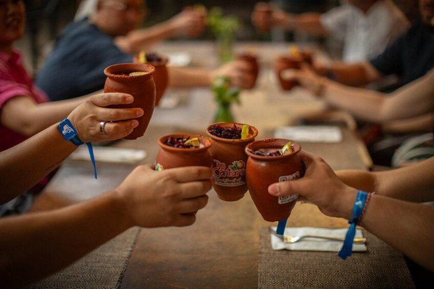 Personas brindando con tazas de barro en una reunión. 4