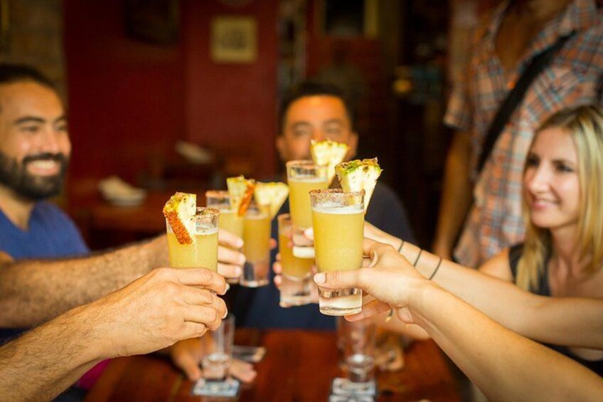 Un grupo de personas brindando con bebidas adornadas con frutas. 5