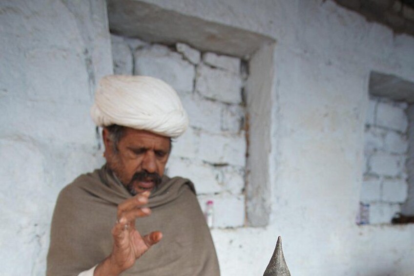 Una persona vestida con atuendo tradicional y un turbante, haciendo un gesto con la mano. 2