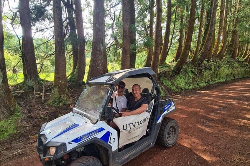 Ett fordon med texten ”UTV-turer” på sig står parkerat på en grusväg, omgivet av träd. 4