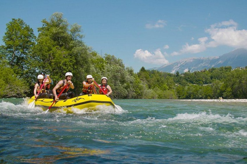 Un grupo de personas haciendo rafting en un río rodeado de exuberante vegetación y montañas. 2