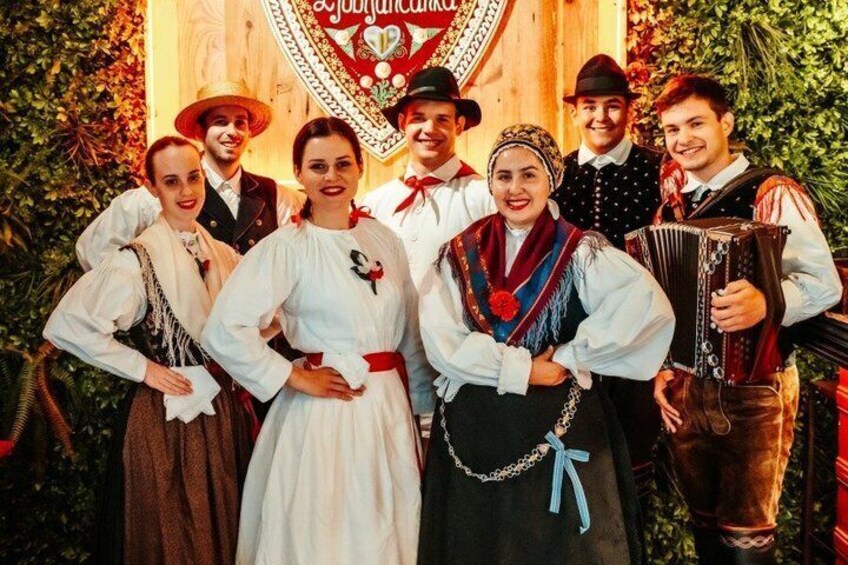 A group of people in traditional attire posing in front of a decorated backdrop. 1