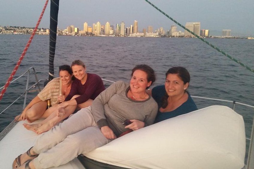 Un grupo de personas navegando en un velero con un horizonte urbano de fondo. 2