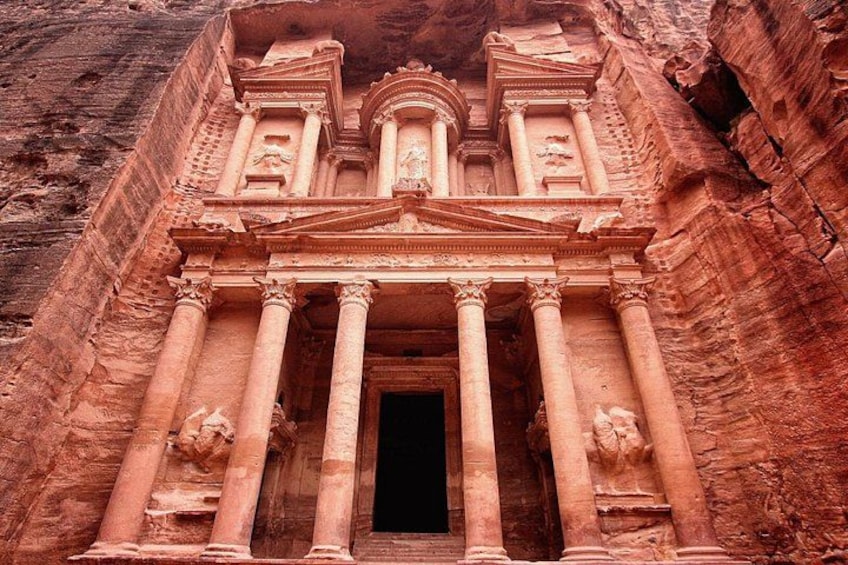 A large, ancient rock-cut temple with columns and a central doorway. 3