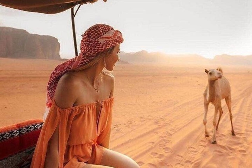A person in a desert landscape with a camel. 4