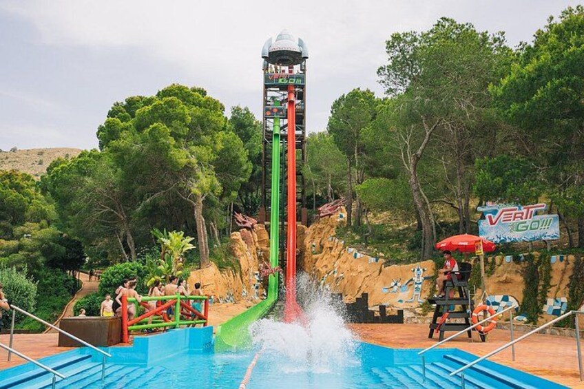 A water slide with a tower, a pool, and a sign that says 'VERT GO!!'. 5