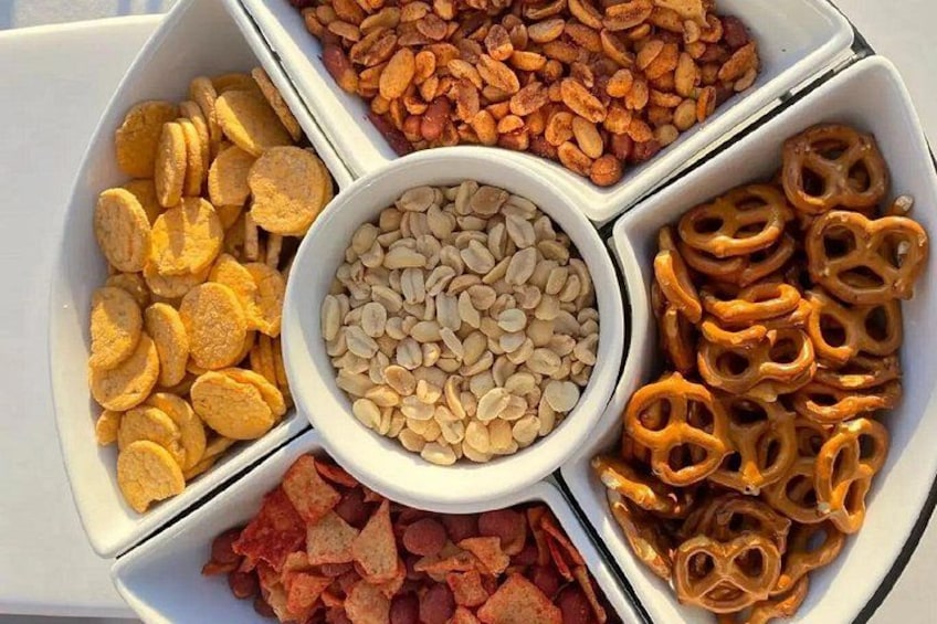 A snack tray with pretzels, sunflower seeds, and dried fruit. 3