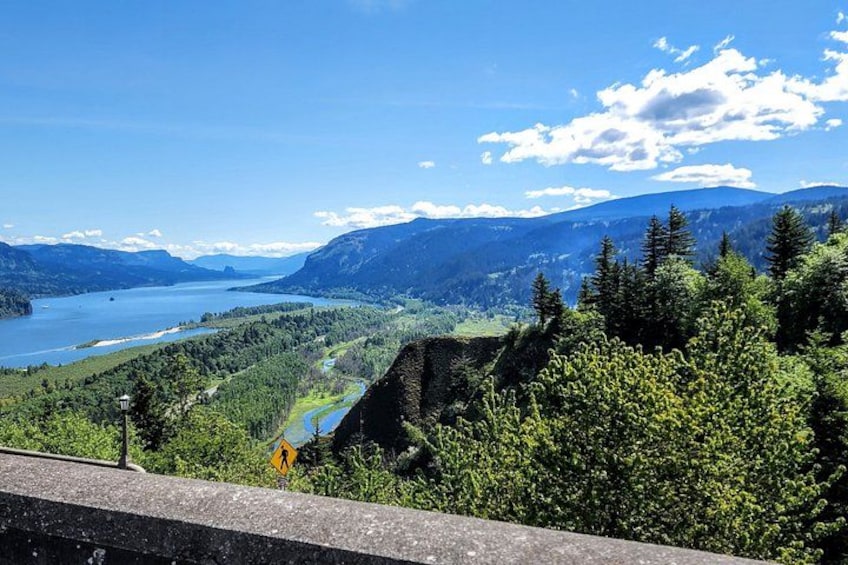 A mountainous landscape with a river, a lake, and a road with a guardrail. 3