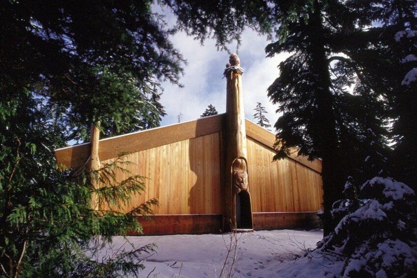 A wooden building with a large column and snow-covered ground. 3