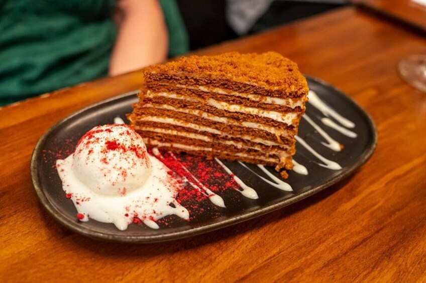 A layered cake with a scoop of ice cream on a plate. 2
