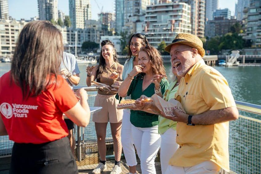 A group of people on a waterfront promenade with a city skyline in the background. 5
