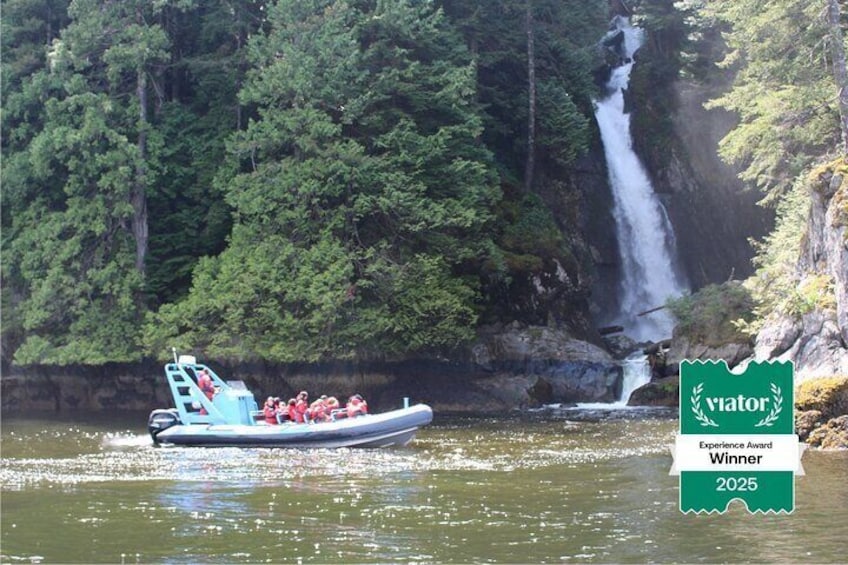 A boat with people on a river with a waterfall in the background. 2