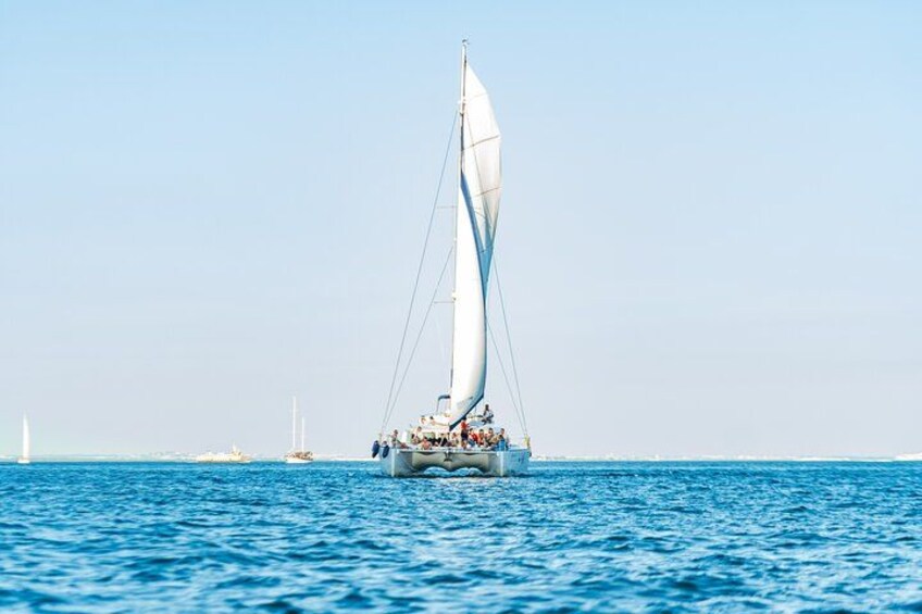 Eine Segelyacht mit mehreren Personen an Bord auf ruhiger See. 2