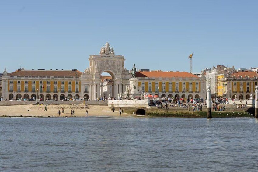 Une promenade en bord de mer agrémentée d’une arche historique, d’une statue et d’une foule de personnes. 2
