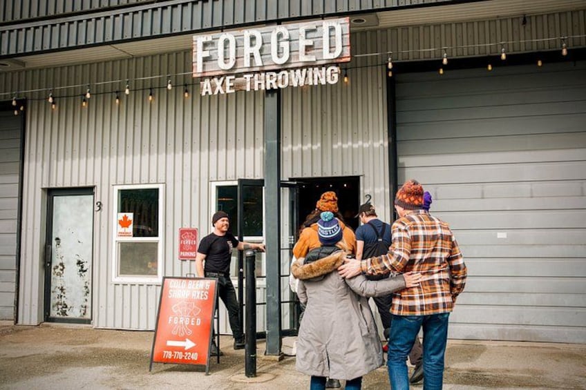 Ein Gebäude mit einem Schild, auf dem 'FORGED AXE THROWING' steht. 3