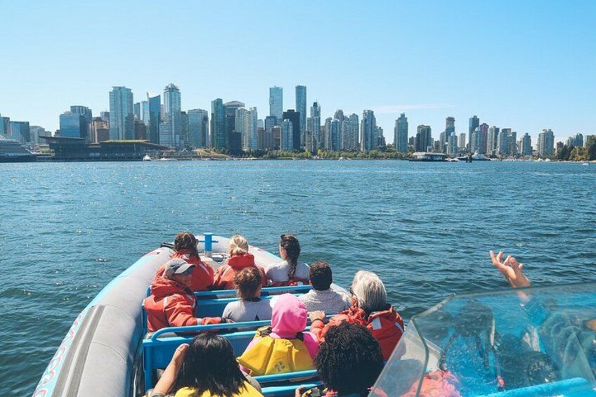 Un grupo de personas en un bote, con un horizonte urbano de fondo. 3