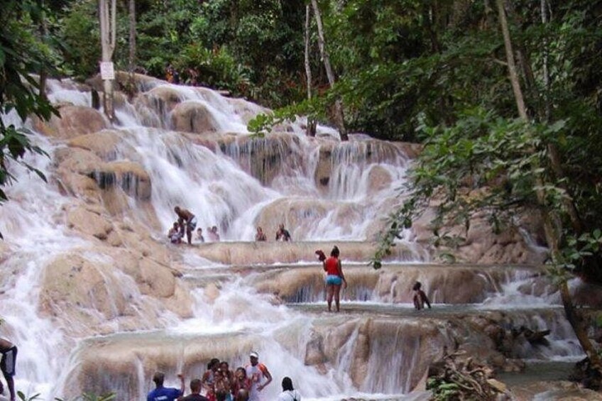 A waterfall with multiple tiers, surrounded by lush greenery. 1