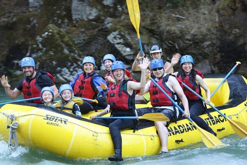 Un groupe de personnes se trouve dans un radeau gonflable jaune sur l’eau, portant des gilets de sauvetage et des casques. 4