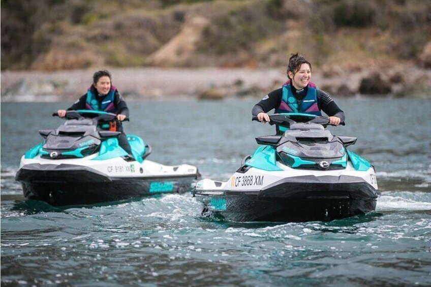 Two people riding jet skis on a body of water. 1