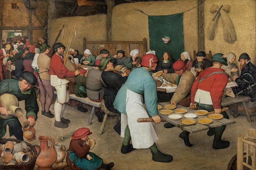 A crowded indoor scene with people engaged in various activities, including food preparation and serving. 2