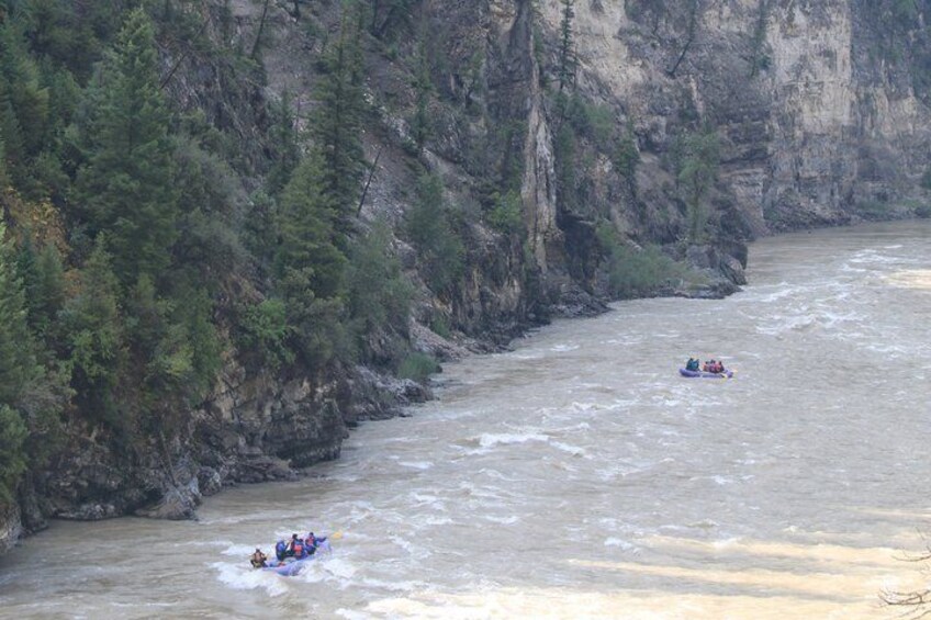 A river with two groups of people rafting. 5