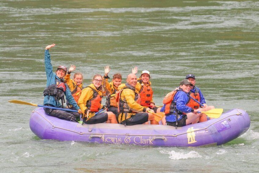 A group of people in a purple inflatable raft on water. 4