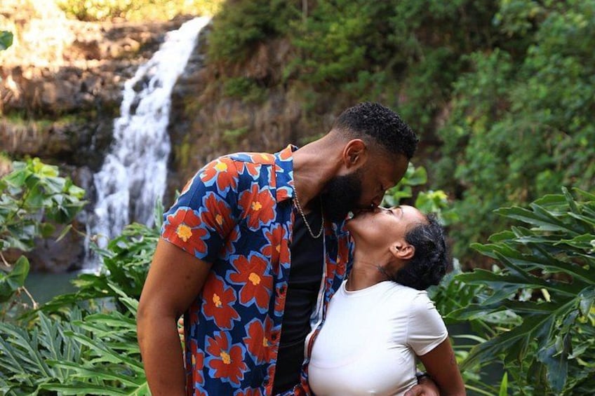 Un couple s’embrasse devant une cascade, entouré d’une végétation luxuriante. 5