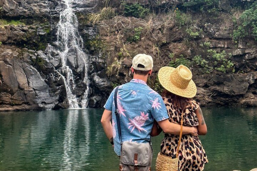 Un couple se tient près d’une cascade, dans un cadre naturel. 2